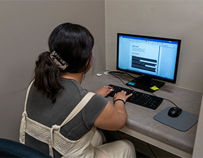 girl sitting in writing center at computer