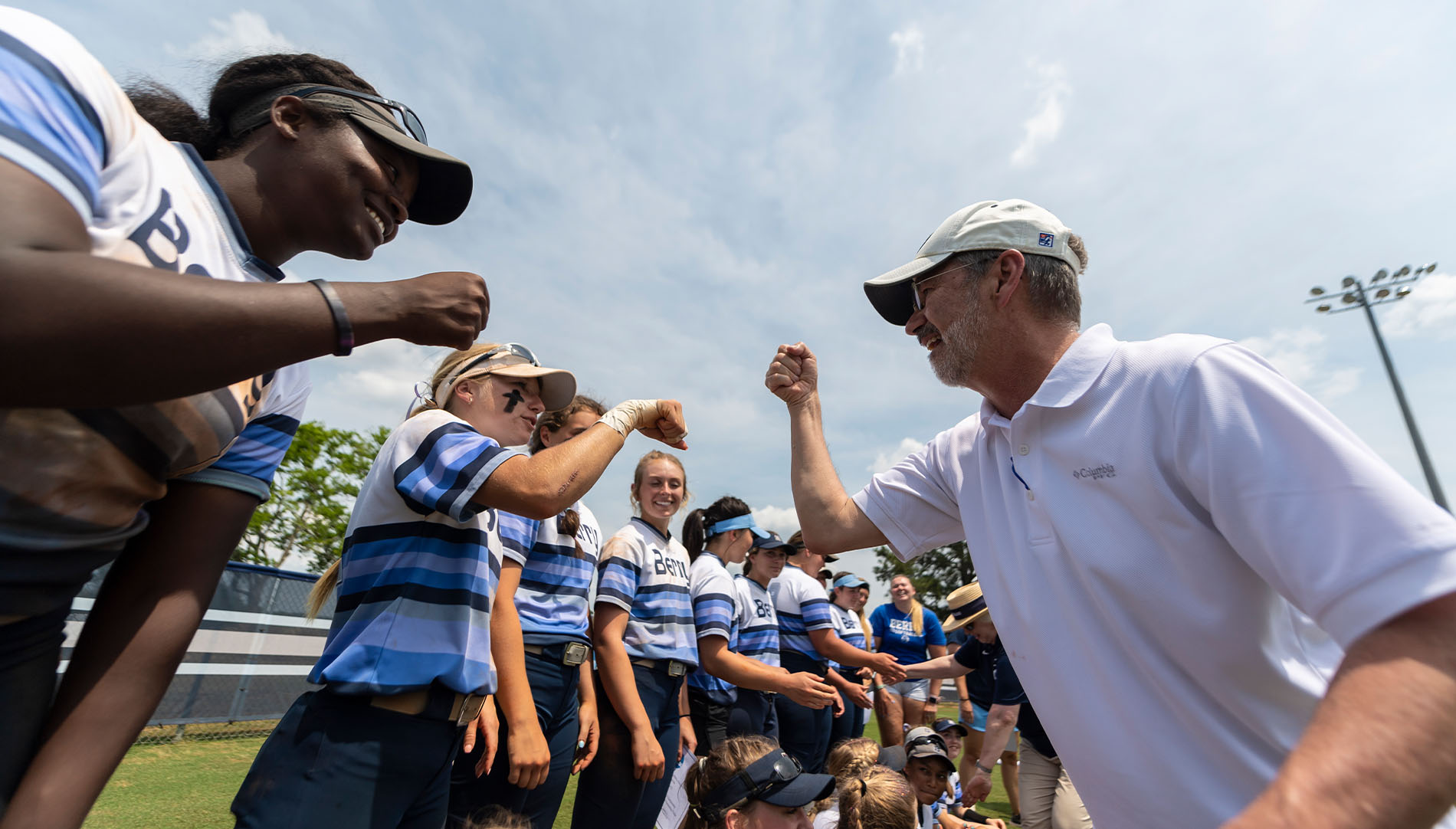 Steve Briggs fist bumping softball players