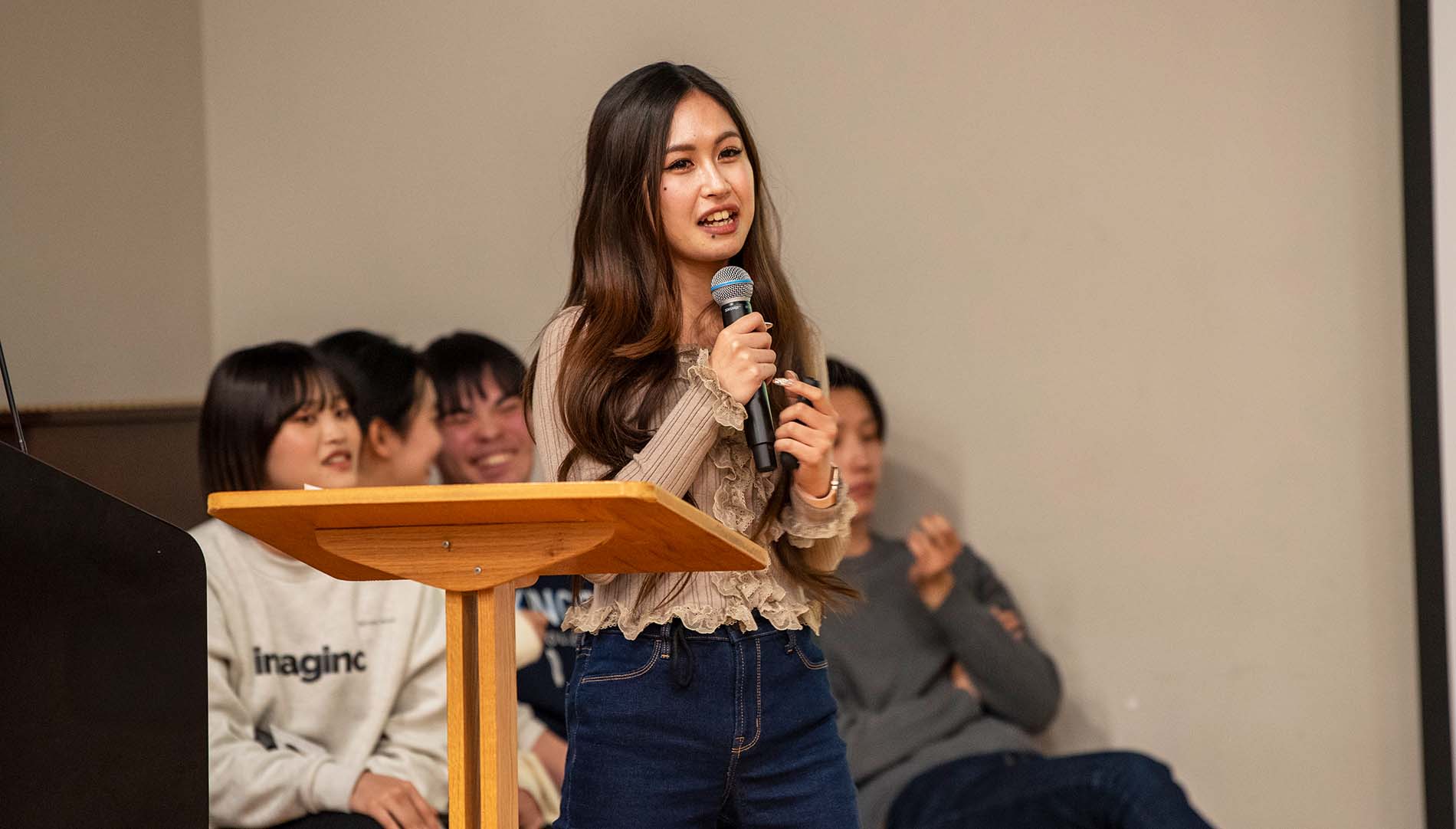 Japanese exchange students speaking at a podium